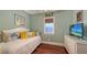 Bright, cozy bedroom with vibrant pillows and hardwood floors at 4941 Commonwealth Dr, Sarasota, FL 34242