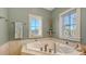 View of the jacuzzi tub in the main bathroom featuring tile detail and two windows for natural light at 4941 Commonwealth Dr, Sarasota, FL 34242