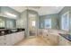 A luxurious main bathroom featuring a jacuzzi tub, a separate shower, dual vanities, and natural light at 4941 Commonwealth Dr, Sarasota, FL 34242
