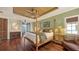 A spacious main bedroom features a four-poster bed, wood floors, a sitting area, and french doors to a balcony at 4941 Commonwealth Dr, Sarasota, FL 34242