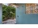 Convenient outdoor shower surrounded by lush landscaping, with stone tile and a decorative glass block window at 4941 Commonwealth Dr, Sarasota, FL 34242