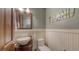 Stylish powder room featuring a bowl sink on a vanity, wood-look floors, and decorative wainscoting at 4941 Commonwealth Dr, Sarasota, FL 34242