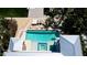Aerial view of a luxurious pool with a spa, surrounded by lush landscaping and a modern architectural design at 511 Bayview Dr, Holmes Beach, FL 34217