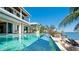 Spacious backyard featuring a luxurious infinity pool, outdoor dining, and waterfront views at 511 Bayview Dr, Holmes Beach, FL 34217