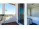 Cozy balcony with wrought iron railing offering views into bedroom and of palm trees under clear blue skies at 511 Bayview Dr, Holmes Beach, FL 34217