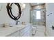 Bright bathroom featuring granite countertop, oval mirror, modern fixtures, and tiled shower with glass door at 511 Bayview Dr, Holmes Beach, FL 34217