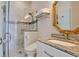 Stylish bathroom features a glass shower, elegant gold mirror, and a marble vanity with modern fixtures at 511 Bayview Dr, Holmes Beach, FL 34217