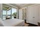 Bedroom featuring a large sliding glass door, water views, and lots of natural light at 511 Bayview Dr, Holmes Beach, FL 34217