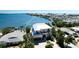 Beautiful two-story waterfront home featuring dual balconies, attached garage, and mature tropical landscaping at 511 Bayview Dr, Holmes Beach, FL 34217