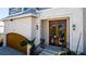 Elegant home entry with a wood door with decorative glass and ironwork, sidelights, and wall sconces at 511 Bayview Dr, Holmes Beach, FL 34217