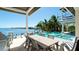 Alfresco dining and pool area overlooking a tranquil waterfront setting, creating a perfect outdoor living space at 511 Bayview Dr, Holmes Beach, FL 34217