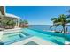 Gorgeous infinity pool with relaxing water views and a covered outdoor dining space at 511 Bayview Dr, Holmes Beach, FL 34217