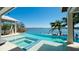 Relaxing infinity pool offering scenic water views, a spa, and a covered outdoor dining area at 511 Bayview Dr, Holmes Beach, FL 34217