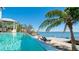 Stunning infinity pool overlooking the waterfront with inviting lounge chairs and dock at 511 Bayview Dr, Holmes Beach, FL 34217