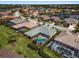 Stunning aerial view of a home with a screened-in pool and lush landscaping in a beautiful community with lakes at 5270 White Ibis Dr, North Port, FL 34287