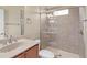 Bright bathroom with a light vanity, toilet, and tiled shower with glass doors at 5270 White Ibis Dr, North Port, FL 34287