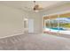 Large bedroom featuring neutral carpet, ceiling fan, and sliding glass doors overlooking the pool at 5270 White Ibis Dr, North Port, FL 34287