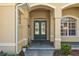 Inviting front entrance with double doors, decorative columns, and manicured landscaping at 5270 White Ibis Dr, North Port, FL 34287