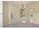 Open-concept living room overlooking pool, featuring chandelier and access to kitchen at 5270 White Ibis Dr, North Port, FL 34287
