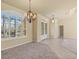 Large living room with shuttered windows, chandelier, and neutral decor leading to dining area at 5270 White Ibis Dr, North Port, FL 34287
