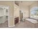 Bright main bathroom with a large tub, double vanity and walk-in closet at 5270 White Ibis Dr, North Port, FL 34287