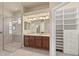 Primary bathroom with a glass-enclosed shower, double vanity, and a large walk-in closet at 5270 White Ibis Dr, North Port, FL 34287