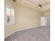 Spacious carpeted main bedroom featuring a ceiling fan and ample natural light from the windows at 5270 White Ibis Dr, North Port, FL 34287