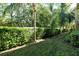 Lush backyard features an abundant natural hedge and green lawn at 5450 Soapstone Pl # 9-103, Sarasota, FL 34233