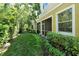 View of a well-maintained backyard, with lush landscaping and a screened-in patio at 5450 Soapstone Pl # 9-103, Sarasota, FL 34233