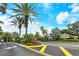 Stonehaven community entrance showcases well-maintained landscaping with swaying palm trees under a bright sky at 5450 Soapstone Pl # 9-103, Sarasota, FL 34233
