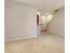 Empty living room with neutral walls, carpet and kitchen bar looking toward the front door at 5450 Soapstone Pl # 9-103, Sarasota, FL 34233