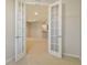 Open living space with neutral walls and carpet visible through glass paneled french doors at 5450 Soapstone Pl # 9-103, Sarasota, FL 34233