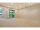 Spacious living room with neutral carpet and a sliding glass door to a patio at 5450 Soapstone Pl # 9-103, Sarasota, FL 34233