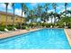 Community pool area with ample seating, palm trees, and a serene setting for residents to enjoy at 5450 Soapstone Pl # 9-103, Sarasota, FL 34233