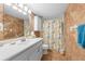 Bathroom with a single sink vanity, decorative tile and a shower with a patterned curtain at 6002 Oak Creek Ln # 1925, Bradenton, FL 34210