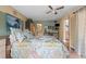Bright bedroom with a floral comforter, tile floors, ceiling fan, and attached bath at 6002 Oak Creek Ln # 1925, Bradenton, FL 34210