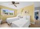 Sunny bedroom features twin beds with white comforters and a window with a lush view at 6002 Oak Creek Ln # 1925, Bradenton, FL 34210