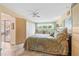 Cozy bedroom featuring a floral comforter, ceiling fan and sliding glass door to a lanai at 6002 Oak Creek Ln # 1925, Bradenton, FL 34210