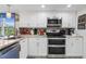 Updated kitchen featuring white cabinets, stainless steel appliances, and granite countertops with tile backsplash at 6002 Oak Creek Ln # 1925, Bradenton, FL 34210
