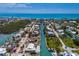 Gorgeous aerial view of canal-front homes, some damaged, with boat docks and stunning ocean backdrop at 619 Bayview Dr, Longboat Key, FL 34228