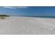 Picturesque beach scene with pristine white sand meeting the calm, turquoise water under a clear blue sky at 619 Bayview Dr, Longboat Key, FL 34228