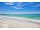 Beautiful shoreline with white sand, gentle waves, and a few seagulls walking near the water's edge at 619 Bayview Dr, Longboat Key, FL 34228