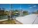 Wide view of modern boat dock equipped with a lift, palms, and a view of the blue coastal waters at 619 Bayview Dr, Longboat Key, FL 34228