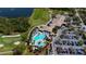 This aerial view features a clubhouse and community pool, bordered by a lake and golf course at 6708 Grand Estuary Trl # 104, Bradenton, FL 34212