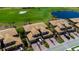 An aerial view of elegant townhomes, showcasing manicured lawns, serene ponds, and a beautiful golf course at 6708 Grand Estuary Trl # 104, Bradenton, FL 34212