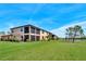 A serene backyard view with lush green grass and screened in patio on a two-story building near a pond at 6708 Grand Estuary Trl # 104, Bradenton, FL 34212