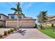 Charming two-story home featuring a paved driveway, two-car garage, and meticulously landscaped front yard at 6708 Grand Estuary Trl # 104, Bradenton, FL 34212