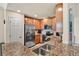 Granite counters highlight this well-equipped kitchen with stainless steel appliances and wood cabinetry at 6708 Grand Estuary Trl # 104, Bradenton, FL 34212