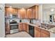 Bright kitchen featuring stainless steel appliances, wood cabinets, and granite countertops at 6708 Grand Estuary Trl # 104, Bradenton, FL 34212