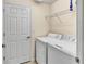 This laundry room features a washer, dryer, overhead shelf and door to another room at 6708 Grand Estuary Trl # 104, Bradenton, FL 34212